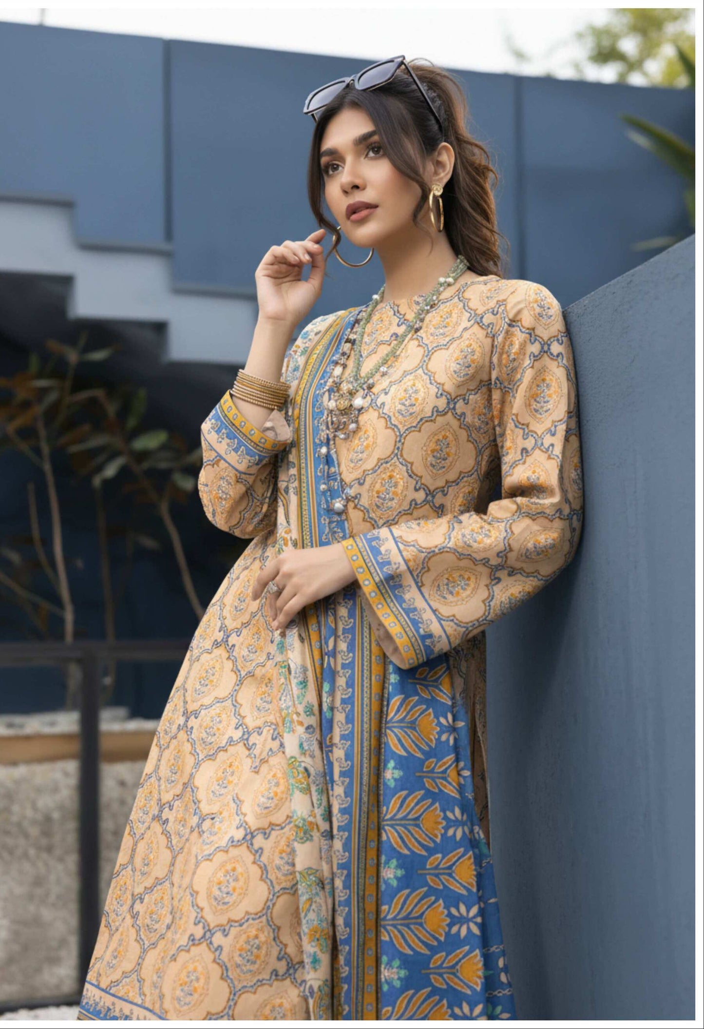 Elegant beige printed 3-piece lawn suit with blue printed dupatta, showcasing traditional design and fine fabric details.