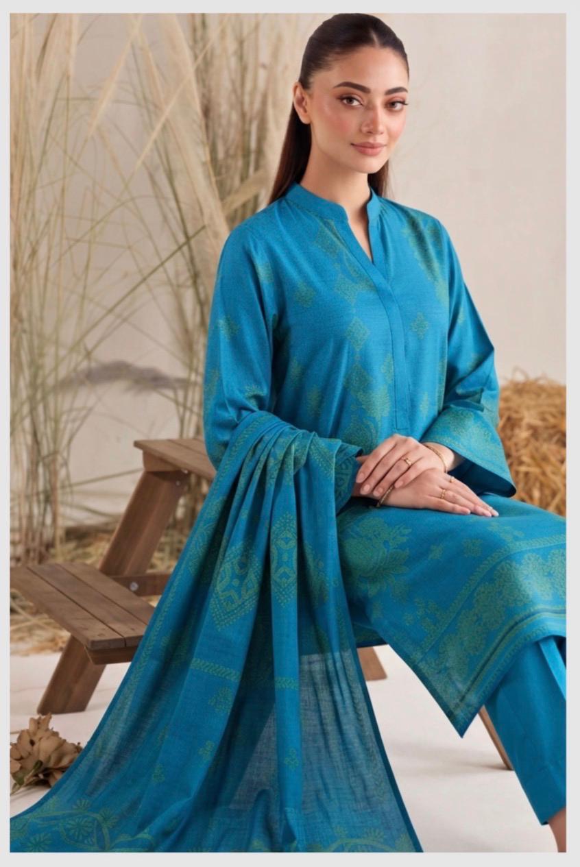 Elegant teal blue printed women’s winter 3-piece suit by Noreya Loom, featuring a stylish top, pants, and matching dupatta.