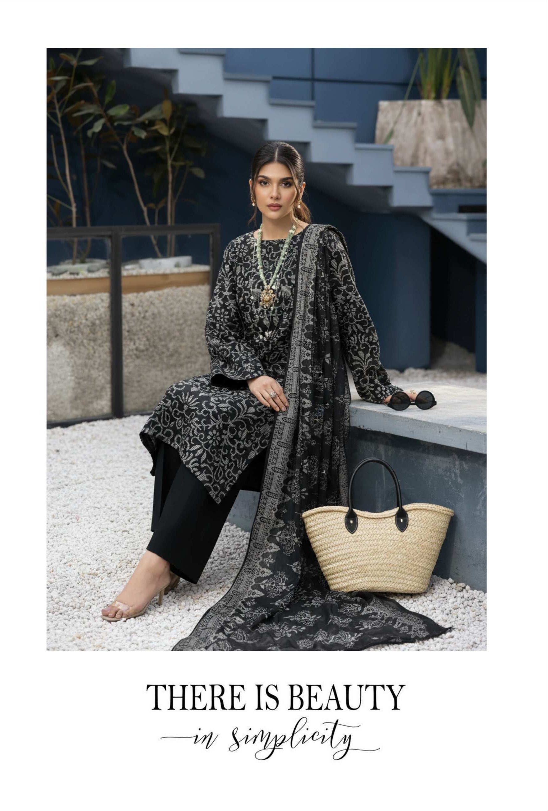 Elegant black and silver printed 3-piece Pakistani suit with intricate designs, showcasing traditional formal attire.