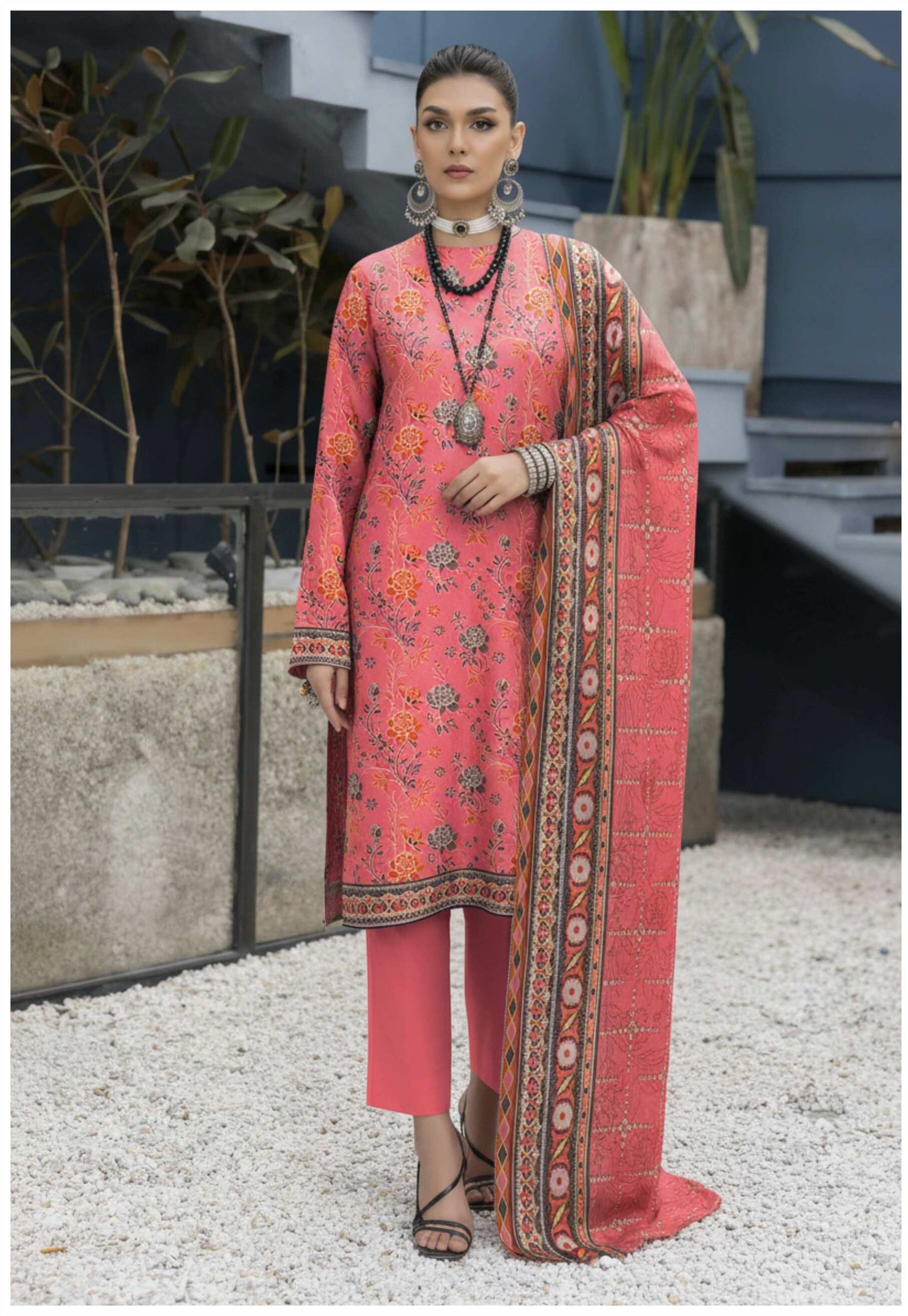 Elegant coral pink floral printed 3-piece suit from Pakistani collection, featuring traditional embroidery and lightweight fabric.